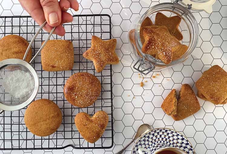 Sprinking icing sugar over honey spiced biscuit recipe
